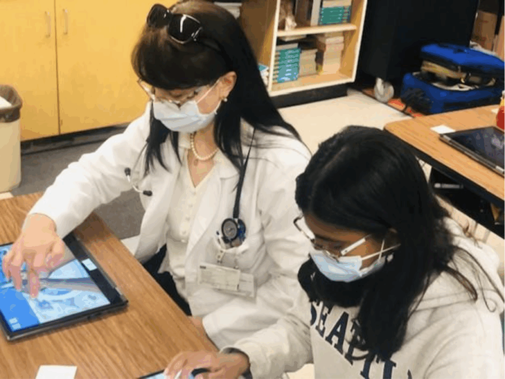 Dr. Criley and a student are playing Bubble Beats Trainer side by side in a classroom setting.